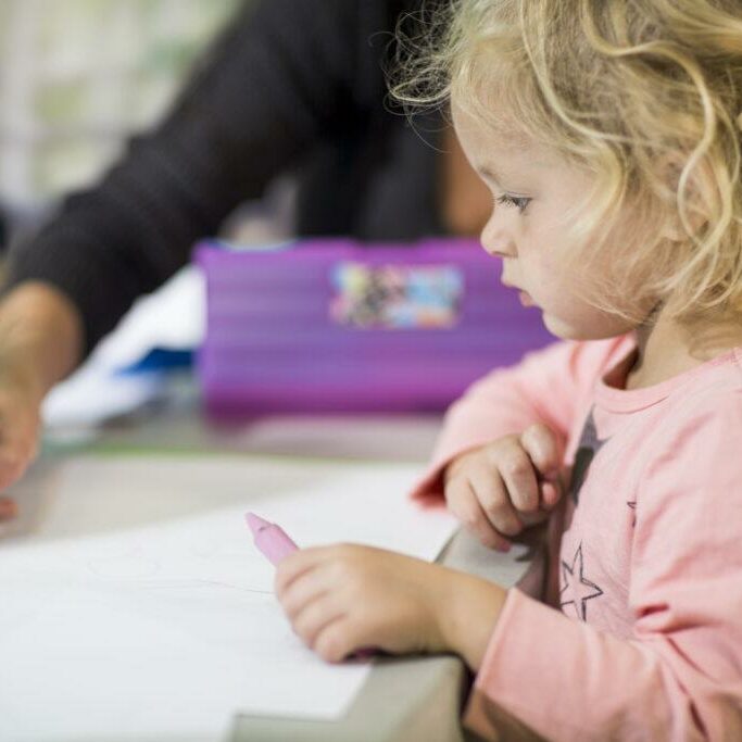 Teacher teaching girl to draw